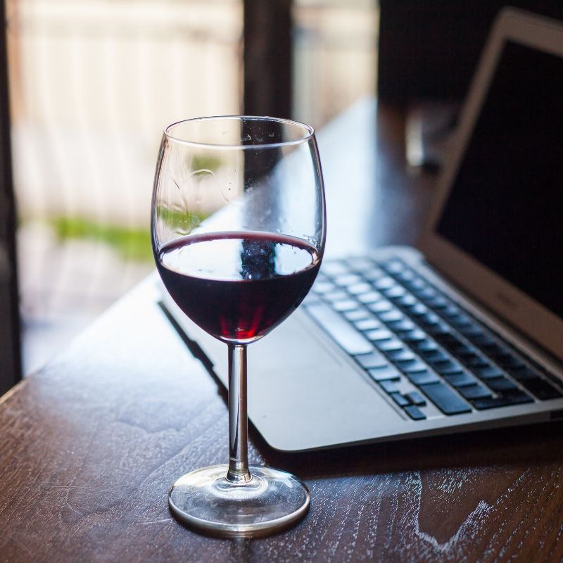 Glass of wine from Small Winery and laptop for online QuickBooks Course for Wineries